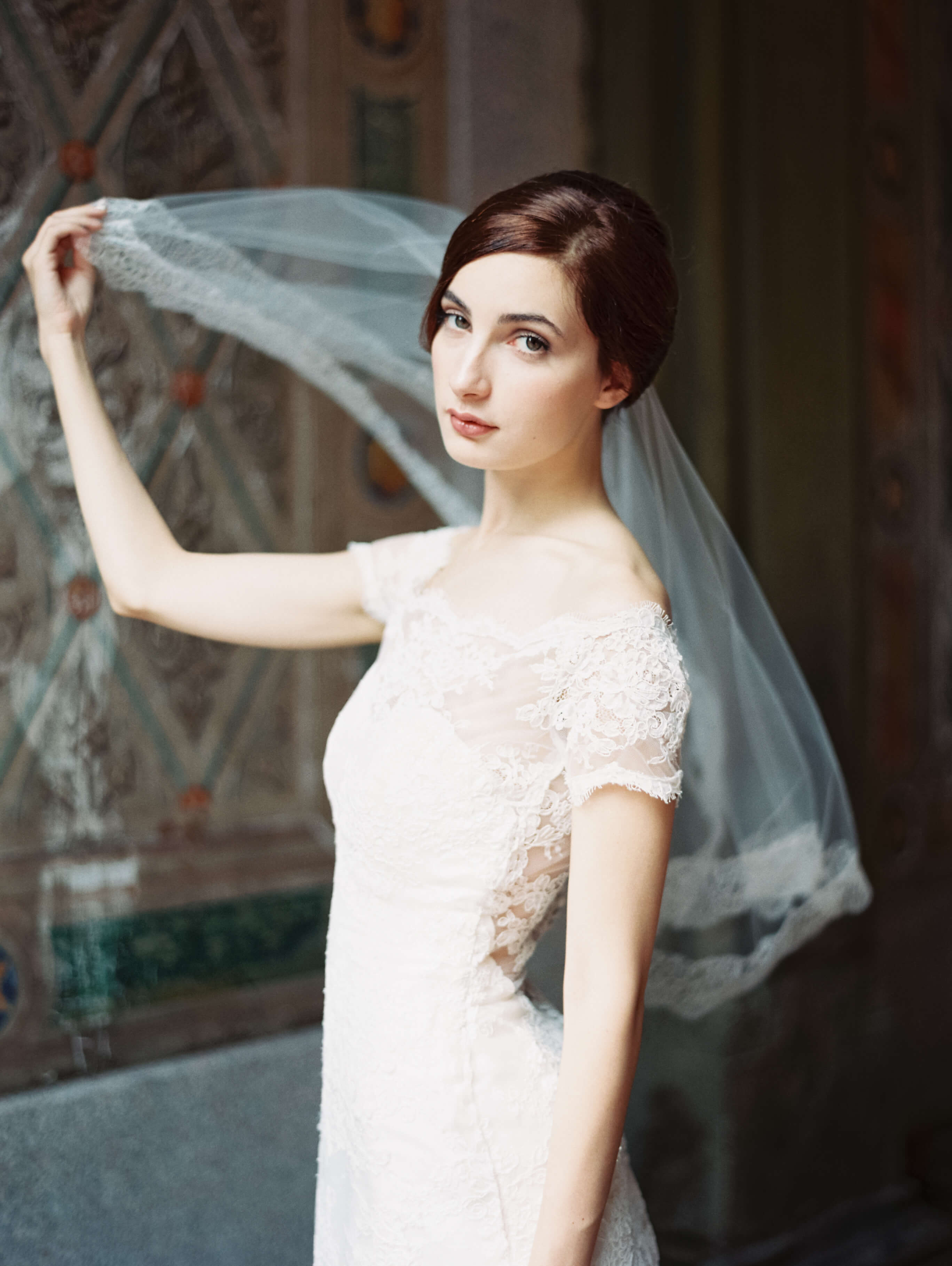 Model wearing bridal gown near the wall under the veil